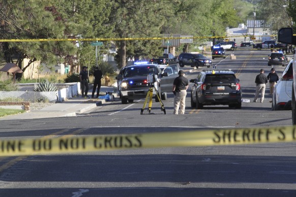Investigators work along a residential street following a deadly shooting Monday, May 15, 2023, in Farmington, N.M. Authorities said an 18-year-old opened fire in the northwestern New Mexico community ...