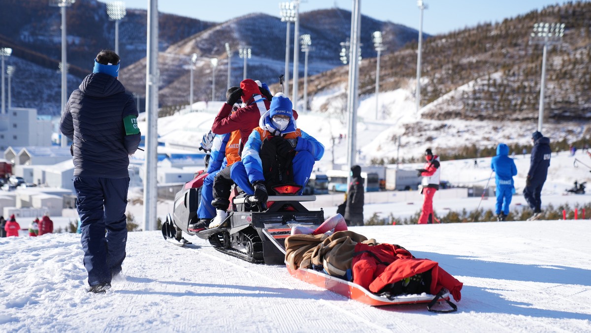 epa09761190 Irene Cadurish of Switzerland is carried on a rescue sled during the Women's Biathlon 4x6km Relay race at the Zhangjiakou National Biathlon Centre at the Beijing 2022 Olympic Games, Z ...
