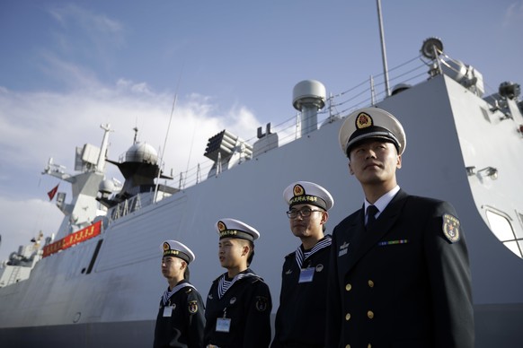 Chinese Navy officials stand in front of the ship Daqing Wednesday, Dec. 7, 2016, in San Diego. Three Chinese Navy ships, two frigates and an oil tanker, are visiting San Diego this week, marking the  ...