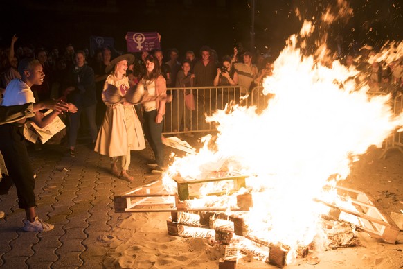 Des femmes brulent un soutien george dans un feu sur la place de la Riponne lors dâune action de lancement de la greve des femmes / greve feministe ce vendredi 14 juin 2019 a Lausanne. (KEYSTONE/Lau ...