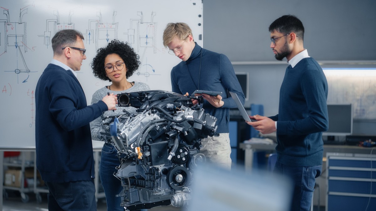 Monsieur Neumann (à gauche) explique le concept de son nouveau moteur à combustion aux représentants des grands groupes automobiles.