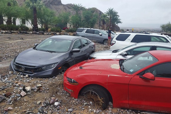 In this photo provided by the National Park Service, cars are stuck in mud and debris from flash flooding at The Inn at Death Valley in Death Valley National Park, Calif., Friday, Aug. 5, 2022. Heavy  ...