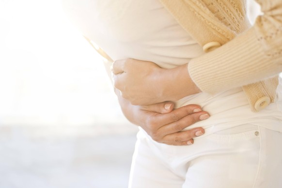 Woman holding stomach Woman holding stomach in pain. *** Woman holding stomach Woman holding stomach in pain PUBLICATIONxINxGERxSUIxHUNxONLY SCIENCExPHOTOxLIBRARY F025/5064