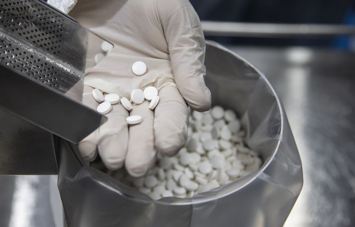 epa08508733 An employee holds tablets of the antiviral medication favipiravir at the laboratories of the Eva Pharma company in Cairo, Egypt, 25 June 2020. Favipiravir appears to have been proven effec ...