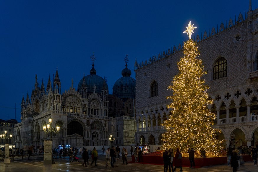 A 15-meter tall Christmas tree is lit in St. Mark&#039;s Square in Venice, northern Italy, Tuesday, Dec. 6, 2022, in front of Palazzo Ducale and St. Mark&#039;s Basilica, left. In cities across Europe ...