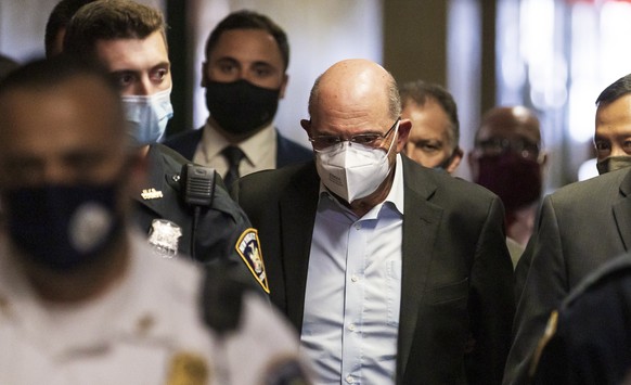 epa09316453 Allen Weisselberg (C), the chief financial officer for the Trump Organization, is escorted by police officers into a court hearing after he turned himself in this morning to face an indict ...