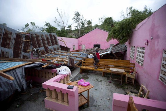 Children sit inside a church destroyed by Hurricane Matthew in Saint-Louis, Haiti, Wednesday, Oct. 5, 2016. Rescue workers in Haiti struggled to reach cutoff towns and learn the full extent of the dea ...