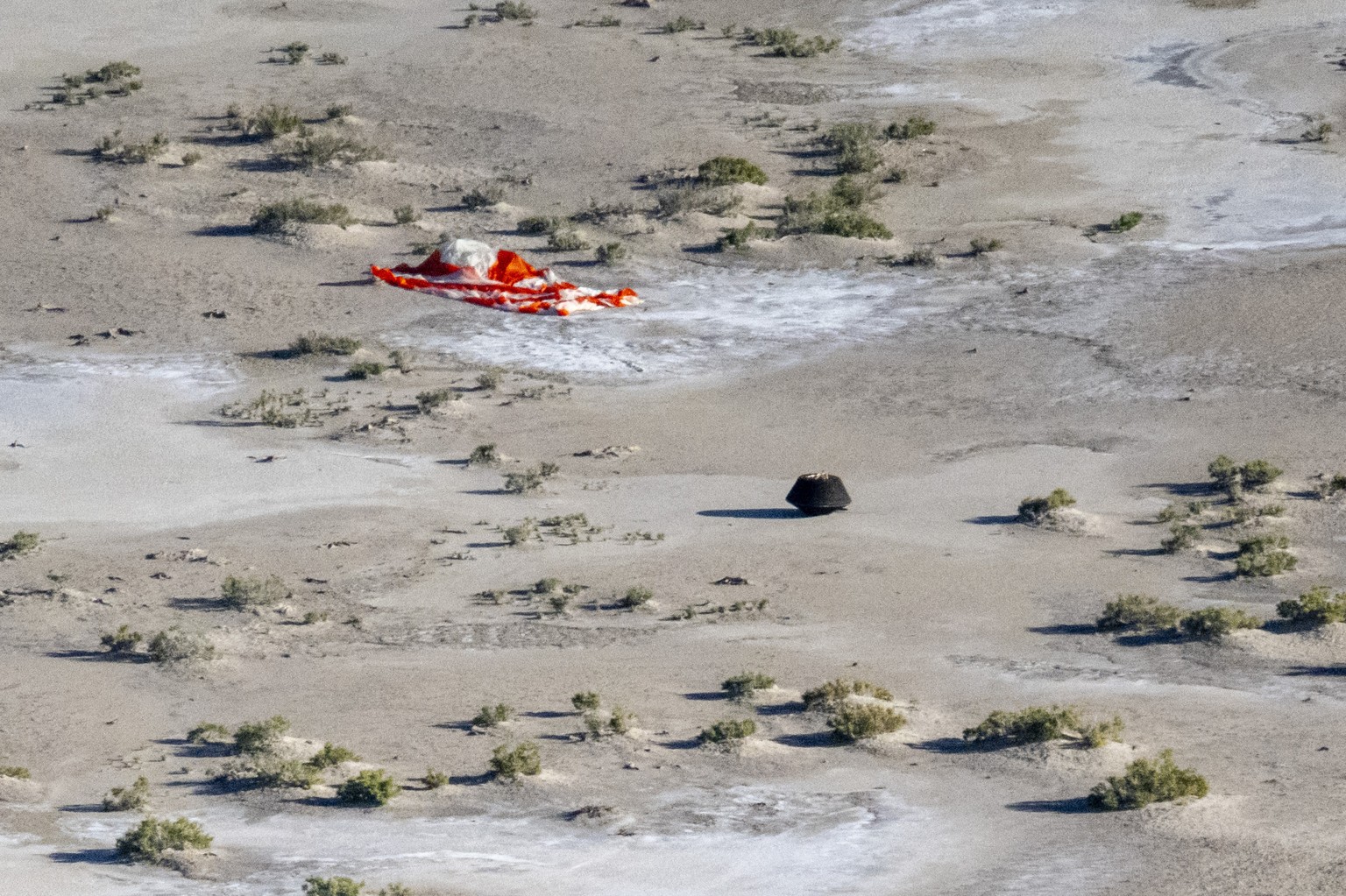 In this photo provided by NASA, the sample return capsule from NASA&#039;s Osiris-Rex mission lies on the ground shortly after touching down in the desert, at the Department of Defense&#039;s Utah Tes ...