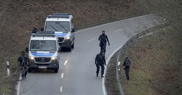 Police officers search for traces on the access road to the scene where two police officers were shot during a traffic stop near Kusel, Germany, Monday, Jan. 31, 2022. Police say two officers have bee ...