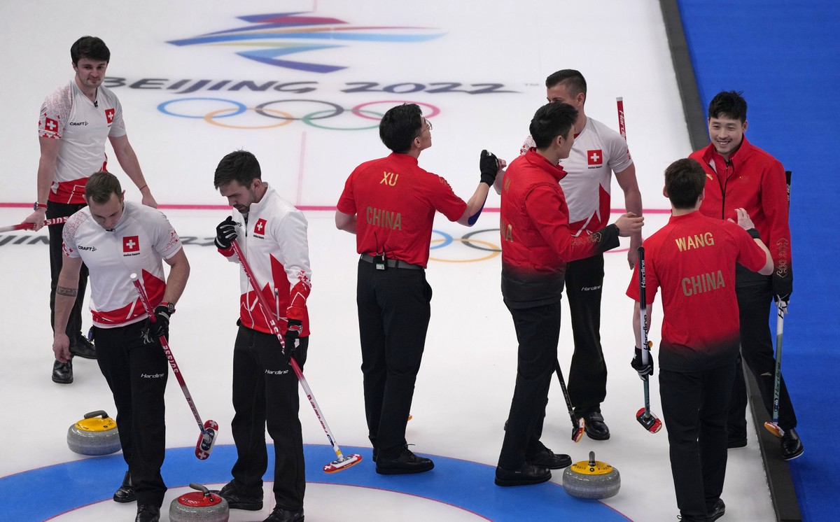 Switzerland's team, in white, congratulates, China's team, after winning the men's curling match against Switzerland, at the 2022 Winter Olympics, Wednesday, Feb. 16, 2022, in Beijing.  ...