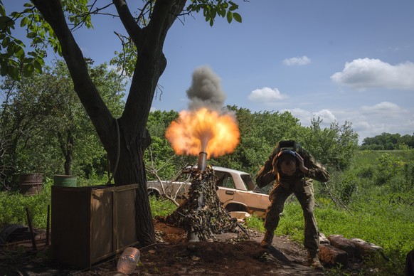 A Ukrainian soldier fires a mortar at Russian positions on the frontline near Bakhmut, Donetsk region, Ukraine, Monday, May 29, 2023. (AP Photo/Efrem Lukatsky)