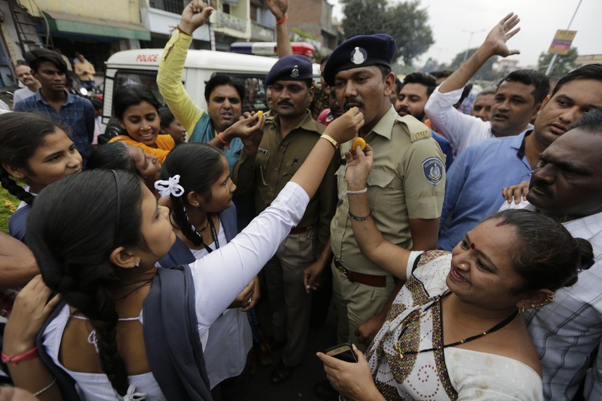 Indian feed sweets to policemen on duty and shout slogans in favor of police to celebrate killing of four men suspected of raping and killing a woman in Shadnagar in southern state of Telangana, in Ah ...