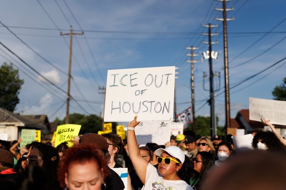 A woman holds a sign reading "ICE OUT OF HOUSTON" during a vigil for Lorenzo Salgado Araujo, a Mexican national fatally shot by a federal immigration agent a day prior, Wednesday, July 8, 20 ...