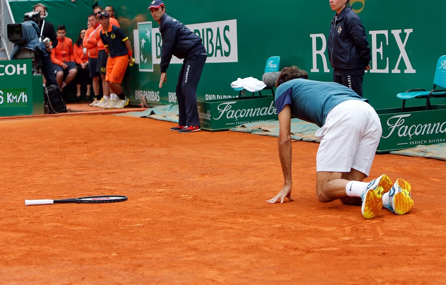 Roger Federer of Switzerland falls on the clay, during their final match of the Monte Carlo Tennis Masters tournament, against Stanislas Wawrinka of Switzerland, in Monaco, Sunday, April, 20, 2014. Wa ...