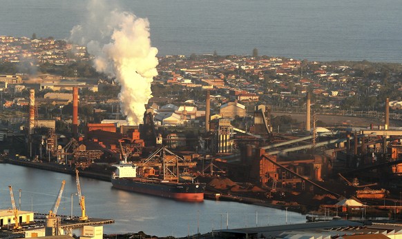 FILE - In this July 2, 2014 file photo, smoke billows out of a chimney stack of BHP steelwork factories at Port Kembla, south of Sydney, Australia. The world's biggest miner, BHP Billiton, on Tuesday, ...