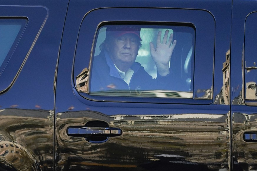 President Donald Trump waves to supporters from his motorcade as people gather for a march Saturday, Nov. 14, 2020, in Washington. (AP Photo/Julio Cortez)