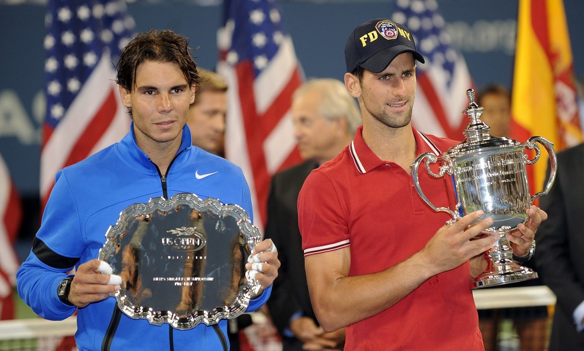 epa02914115 Novak Djokovic of Serbia holds up the championship trophy (L) and Rafael Nadal of Spain holds the runner-up trophy (L) after the men's final match on the fifteenth day of the 2011 US  ...
