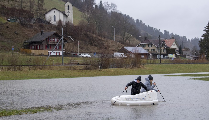 Kinder vergnuegen sich mit einer Gummiinsel auf einem Schmelzwassersee, am Samstag 30. Januar 2021, im Luzerner Hinterland bei Hueswil. Der viele Regen und das Schmelzwasser liessen vielerorts die Bae ...