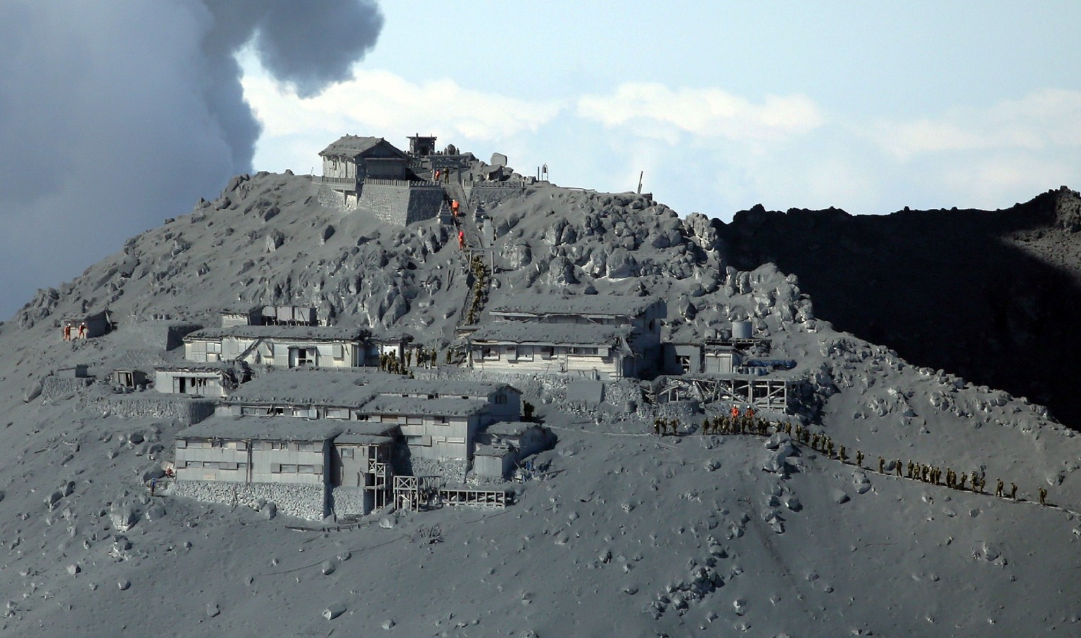 Bis zu 540 Rettungskräfte begeben sich auf die Suche nach vermissten Personen. Das Marschieren auf dem 3067 Meter hohen Berg ist für die Einsatzkräfte wegen der dicken Ascheschicht extrem anstrengend.