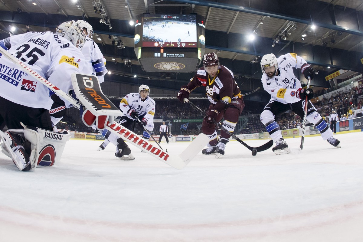 Geneve-Servette's center Kevin Romy, 2nd right, scores the 1:0 against Fribourg's goaltender Ludovic Waeber, left, past Fribourg's players forward Nathan Marchon, 2nd left, and forward  ...