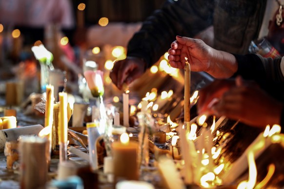 epa09520323 Parishioners light candles and pray during a mass at the National Shrine of Our Lady of Aparecida in the city of Aparecida, located 170 kilometers from Sao Paulo, Brazil, 12 October 2021.  ...