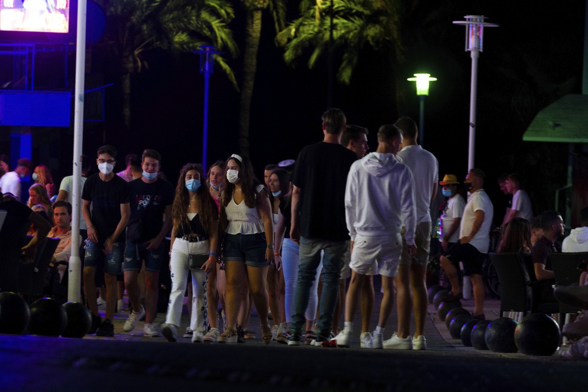 Tourists walk at the street as others stand in a terrace at the resort of Magaluf on the Spanish Balearic island of Mallorca, Spain, Thursday, July 16, 2020. Authorities in Spain's Balearic Islan ...