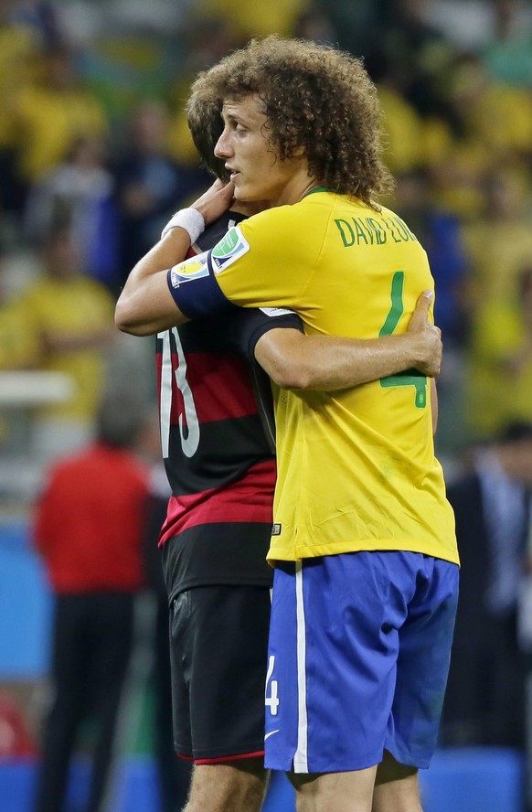 epa04306500 Germany's Thomas Mueller (L) and Brazil's David Luiz (R) hug after Germany won the FIFA World Cup 2014 semi final match between Brazil and Germany at the Estadio Mineirao in Belo ...