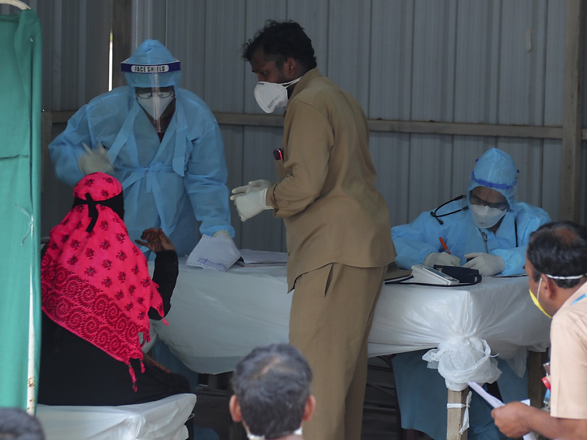 Ein indischer Arzt spricht mit einer Frau mit Covid-19-Symptomen in der Anmeldestelle des Krankenhauses "Government Fever Hospital". Foto: Mahesh Kumar A/AP/dpa