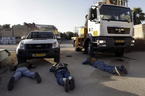 Israelische Arbeiter bringen sich beim Bombenalarm in Schutz
