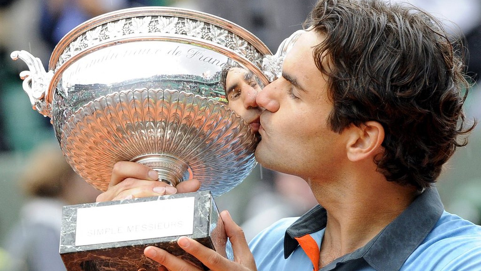 epa01754654 Switzerland&#039;s Roger Federer celebrates with the trophy after winning the final match against Sweden&#039;s Robin Soderling in the French Open tennis tournament at Roland Garros in Par ...