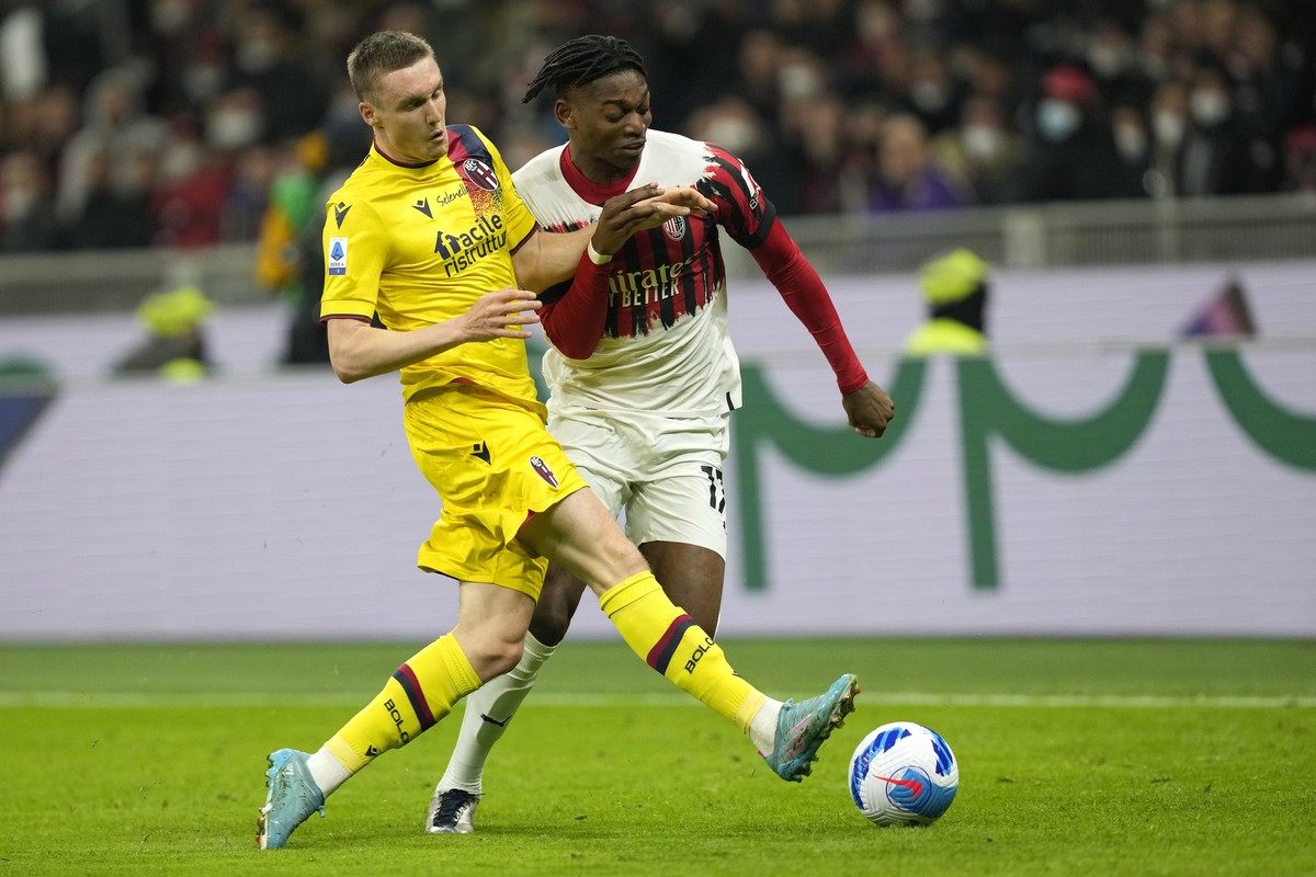 AC Milan's Rafael Leao, right, and Bologna's Michel Aebischer fight for the ball during the Serie A soccer match between AC Milan and Bologna at the San Siro stadium, in Milan, Italy, Monday ...
