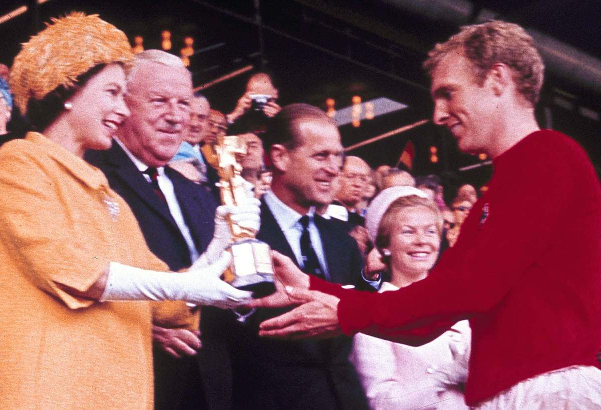 FILE - In this July 30, 1966 file photo Queen Elizabeth II presents the World Cup, the Jules Rimet trophy, to England's team captain Bobby Moore. England beat Germany in the final at London' ...