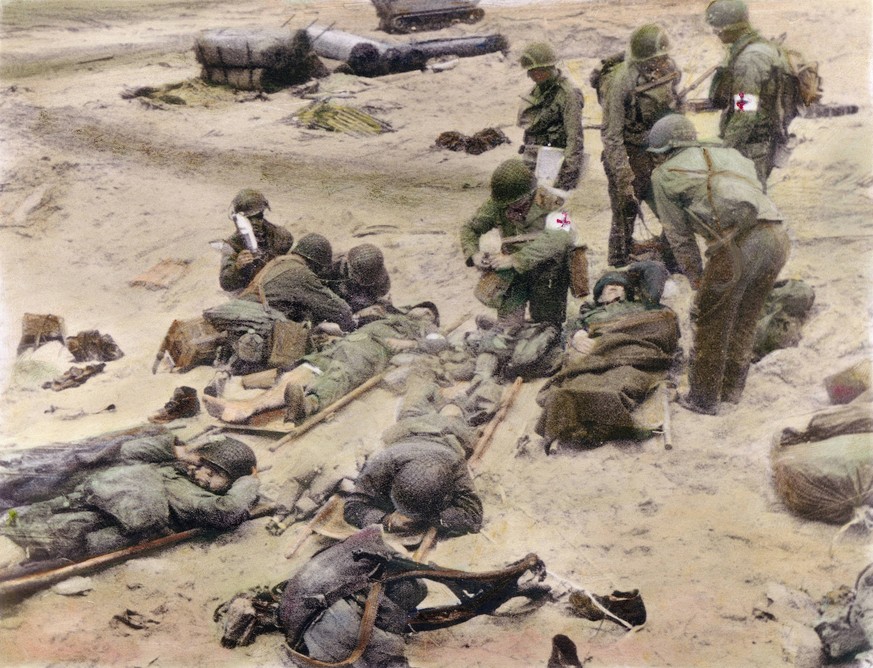 WORLD WAR II: D-DAY, 1944. American medics administer first aid to soldiers wounded in the initial attack at Omaha Beach during the invasion of Normandy, France, 9 June 1944. Oil over a photograph. PU ...