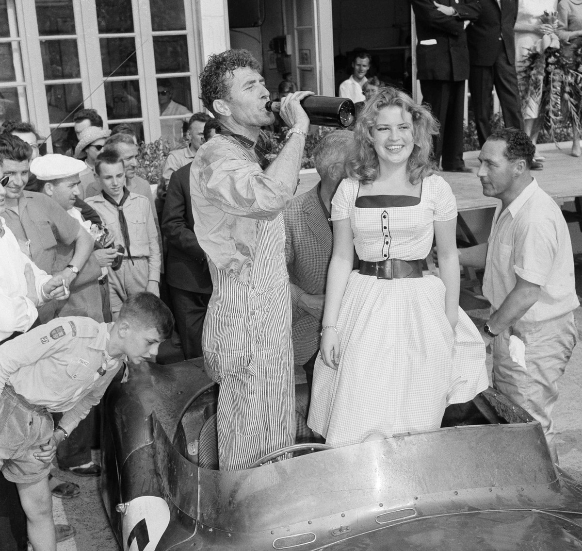 Texas driver Carroll Shelby enjoys swig of champagne after combining with British veteran Roy Salvadori to win the 24-Hour Endurance Auto Classic at Le Mans, France, on June 21, 1959. Dressing up the  ...