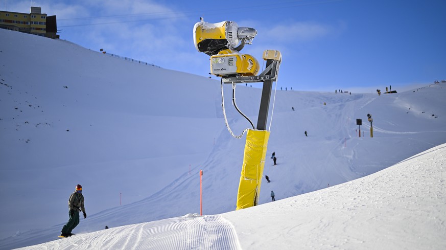 Snowboarder und Schneekanone, aufgenommen bei der Eroeffnung der Skisaison, am Samstag, 19. November 2022, auf Parsenn in Davos. (KEYSTONE/Gian Ehrenzeller)