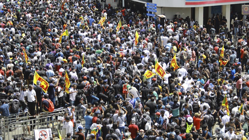 Protesters, some holding Sri Lankan flags, gather in a street leading to the presidents official residence in Colombo, Sri Lanka, Saturday, July 9, 2022. Sri Lankan protesters demanding that President ...