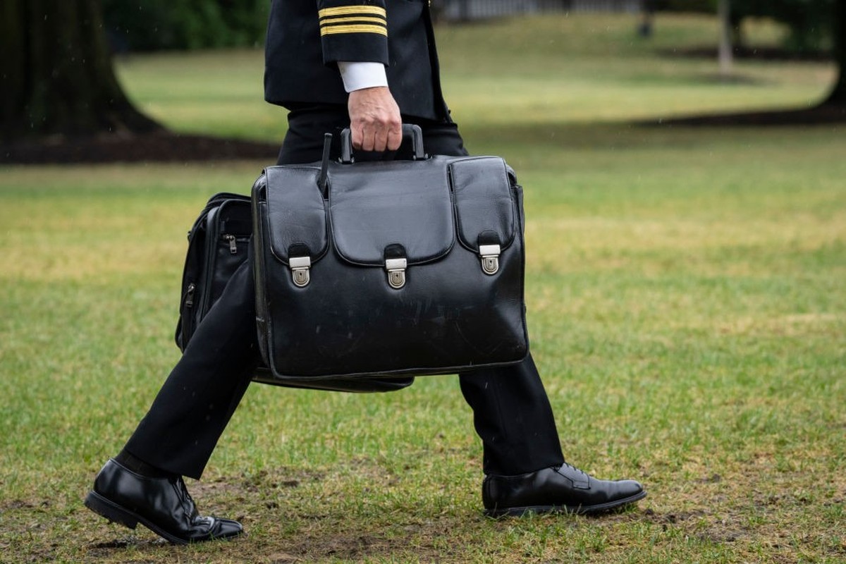 WASHINGTON, DC - OCTOBER 3: A military aide carries the "nuclear football," which contains launch codes for nuclear weapons, while walking to Marine One on the South Lawn of the White House  ...