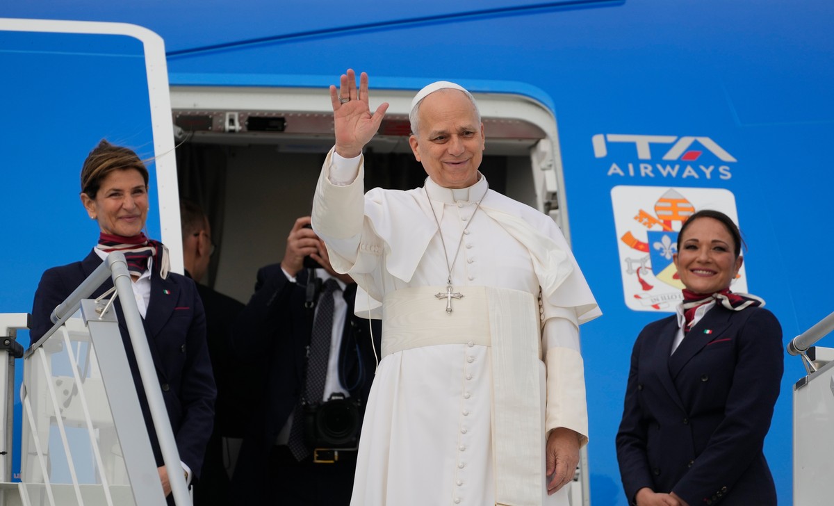 Pope Leo XIV waves before boarding a flight to Algiers at Rome's Leonardo da Vinci-Fiumicino International Airport, Monday, April 13, 2026, marking the start of an 11-day apostolic journey to Afr ...