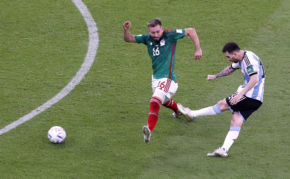 epaselect epa10331194 Lionel Messi (R) of Argentina shoots to score the opening goal against Hector Herrera of Mexico during the FIFA World Cup 2022 group C soccer match between Argentina and Mexico a ...