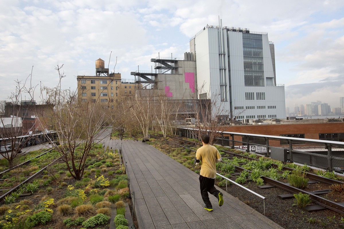 In this Tuesday, April 21, 2015 photo, a runner on New York's High Line runs toward the Whitney Museum of American Art, right. The Whitney opens the doors to its new home on May 1. It’s an asymme ...