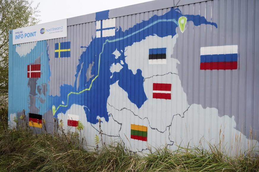 FILE - A sign reading &quot;Nord Stream 2 Committed. Reliable. Safe.&quot; hangs above a painted map at the natural gas receiving station in the Lubmin industrial estate in Lubmin, Germany, Nov 16, 20 ...