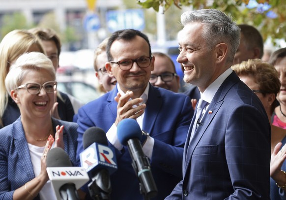 Poland&#039;s most prominent gay politician Robert Biedron, right, is applauded as he announces a start of his new political movement during a press conference in Warsaw, Poland, Tuesday, Sept. 4, 201 ...