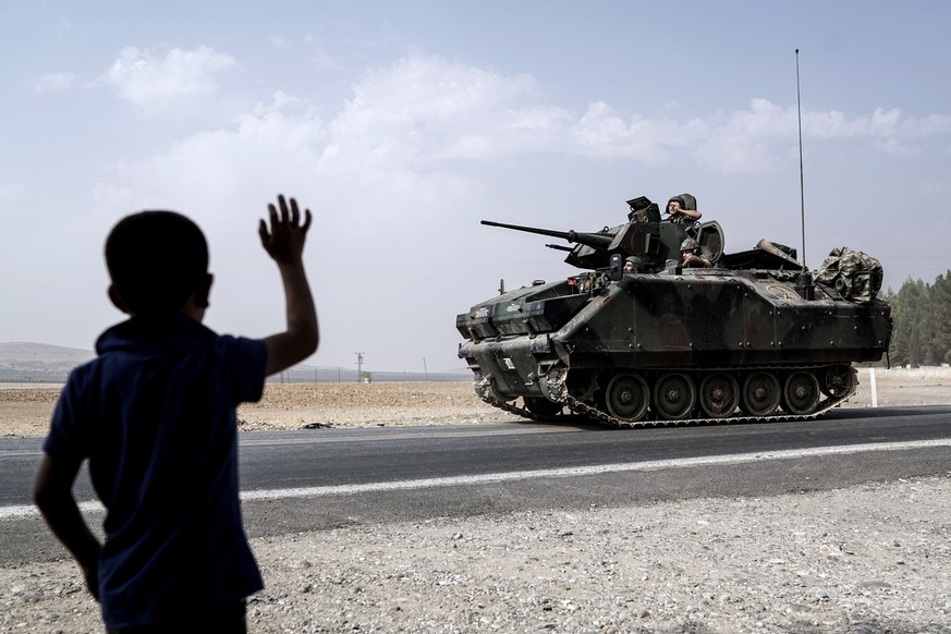 A child waves toward Turkish troops heading to the Syrian border, in Karkamis, Turkey, Friday, Aug. 26, 2016. Turkey&#039;s state-run Anadolu news agency said late Thursday Turkish artillery have shel ...