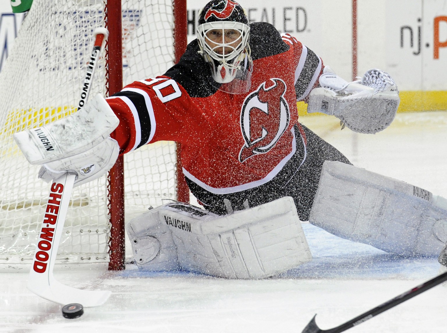 FILE - In this March 4, 2014, file photo, New Jersey Devils goaltender Martin Brodeur deflects the puck during the first period of an NHL hockey game against the Detroit Red Wings in Newark, N.J. Brod ...