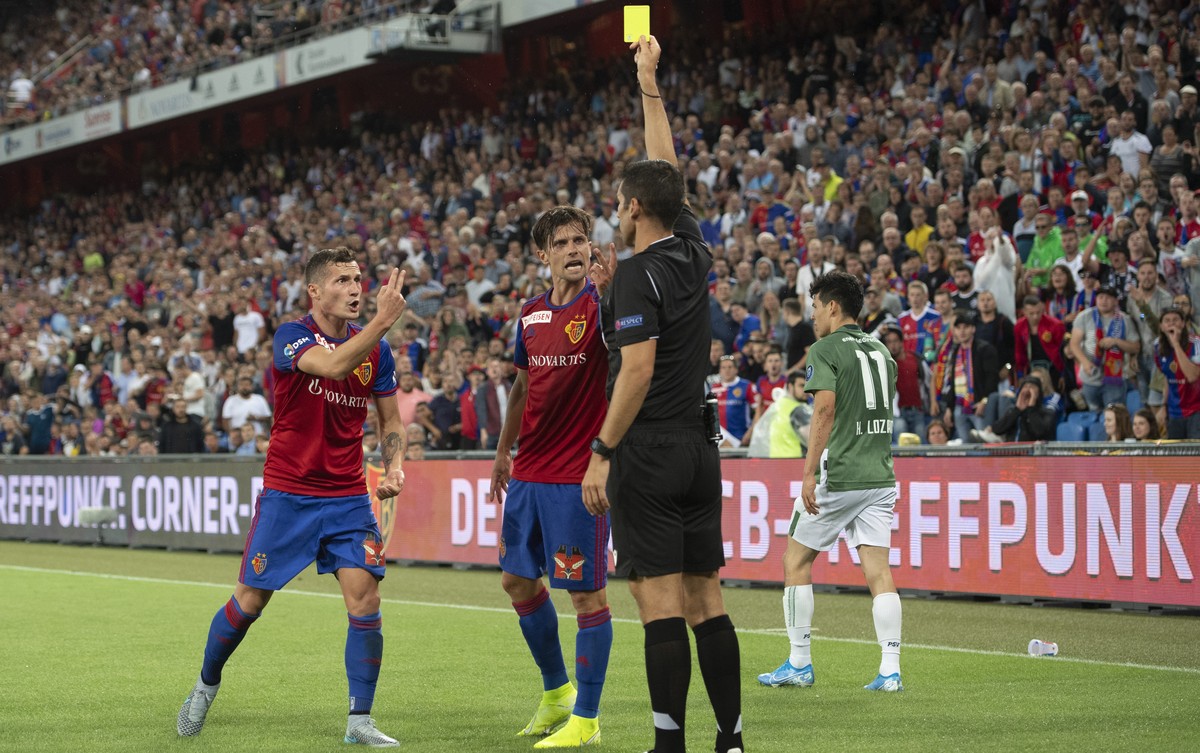 Basel's Taulant Xhaka, Valentin Stocker and Portuguese referee Fabio Verissimo, from left, during the UEFA Champions League second qualifying round second leg match between Switzerland's FC  ...