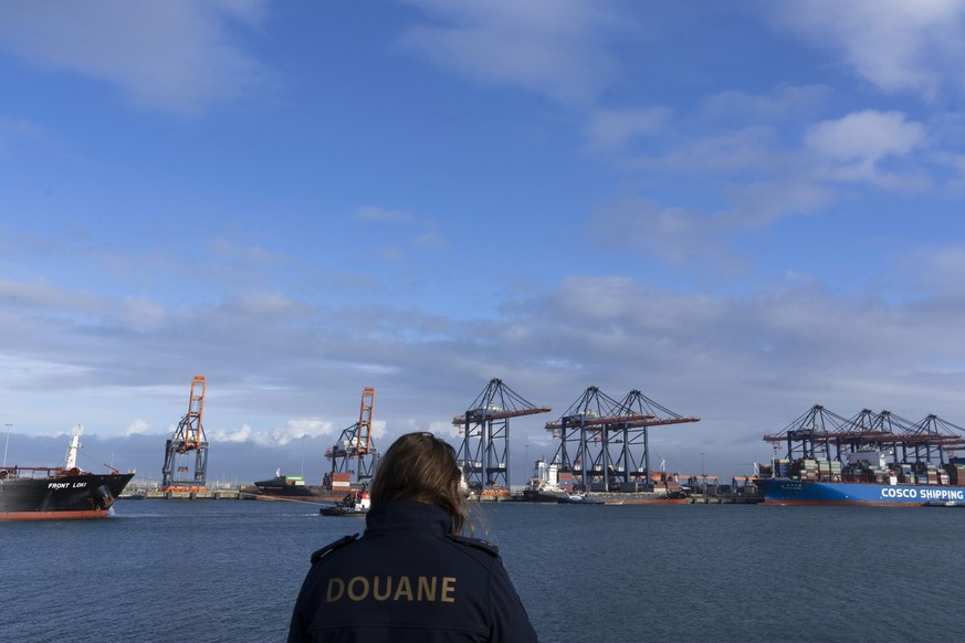 A Dutch customs officer poses for the media as containers are being unloaded at the Maasvlakte container terminal location in the port of Rotterdam, Netherlands, Monday, Jan. 9, 2023. Cocaine is sprea ...