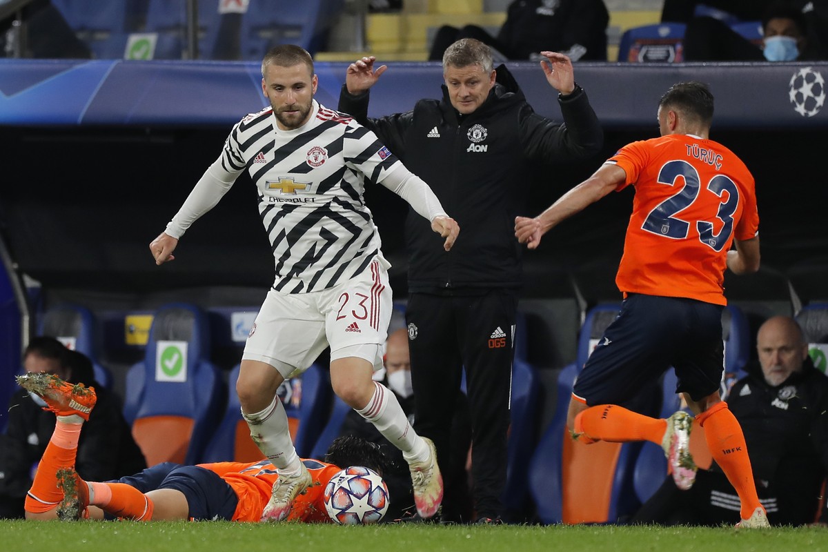 Manchester United's manager Ole Gunnar Solskjaer, background, gestures as Manchester United's Luke Shaw, left, fights for the ball with Basaksehir's Aziz Behich during the Champions Lea ...