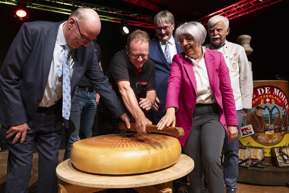 Markus Ritter, Nationalrat Mitte-SG, Daniel Meyer, Praesident Emmentaler Switzerland, und Bundesraetin Elisabeth Baume-Schneider, vorne von links, teilen einen Emmentaler Kaese, bei der offiziellen Er ...