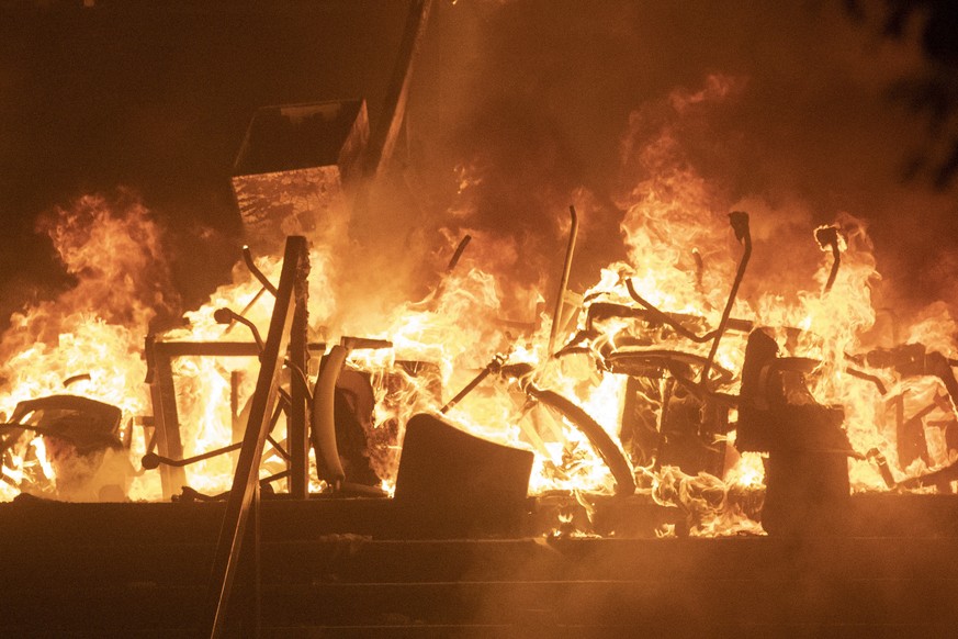 Office chairs burn after police try to storm the Hong Kong Polytechnic University in Hong Kong Monday, Nov. 18, 2019. Fiery explosions were seen early Monday as Hong Kong police stormed into a univers ...