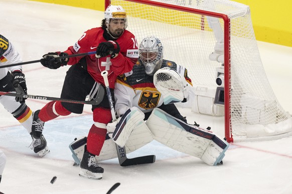 epa11363343 Switzerland's Andres Ambuehl (L) in action against Germany's goalkeeper Harald Grubauer during the IIHF Ice Hockey World Championship 2024 quarter-finals match of Switzerland aga ...